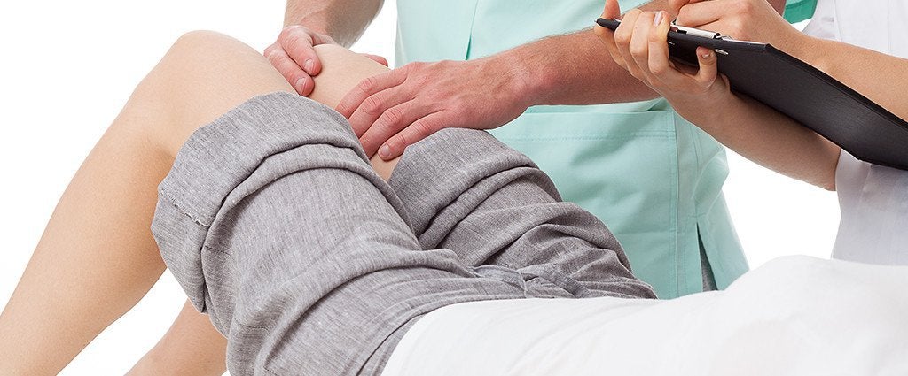 Doctor treating a patient's knee pain in Sandusky, OH